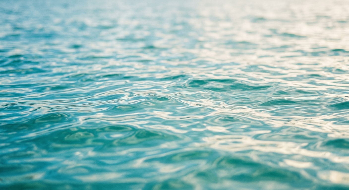 Close-up abstract of rippled ocean water with soft teal and blue light reflections